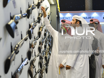 People check a hunting rifle in the guns section at the 8th edition of Katara International Hunting and Falcons Exhibition 2024 (S'hail) at...