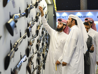 People check a hunting rifle in the guns section at the 8th edition of Katara International Hunting and Falcons Exhibition 2024 (S'hail) at...