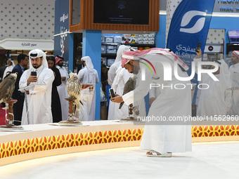 Qatari visitors observe falcons during the 8th edition of the Katara International Hunting and Falcons Exhibition 2024 (S'hail) at Katara Cu...