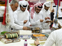 Qatari visitors visit a hunting accessories stall during the 8th edition of the Katara International Hunting and Falcons Exhibition 2024 (S'...