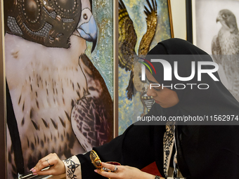 An artist paints a falcon during the 8th edition of the Katara International Hunting and Falcons Exhibition 2024 (S'hail) at Katara Cultural...