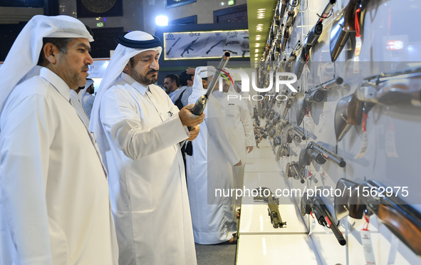 People check a hunting rifle in the guns section at the 8th edition of Katara International Hunting and Falcons Exhibition 2024 (S'hail) at...