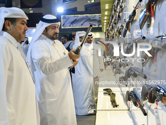 People check a hunting rifle in the guns section at the 8th edition of Katara International Hunting and Falcons Exhibition 2024 (S'hail) at...