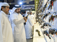 People check a hunting rifle in the guns section at the 8th edition of Katara International Hunting and Falcons Exhibition 2024 (S'hail) at...