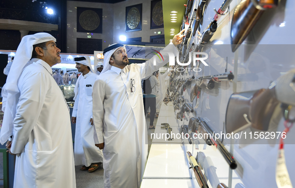 People check a hunting rifle in the guns section at the 8th edition of Katara International Hunting and Falcons Exhibition 2024 (S'hail) at...