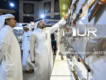 People check a hunting rifle in the guns section at the 8th edition of Katara International Hunting and Falcons Exhibition 2024 (S'hail) at...