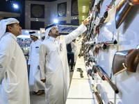 People check a hunting rifle in the guns section at the 8th edition of Katara International Hunting and Falcons Exhibition 2024 (S'hail) at...