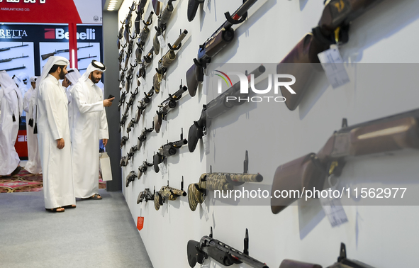 People check a hunting rifle in the guns section at the 8th edition of Katara International Hunting and Falcons Exhibition 2024 (S'hail) at...