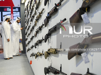 People check a hunting rifle in the guns section at the 8th edition of Katara International Hunting and Falcons Exhibition 2024 (S'hail) at...