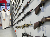 People check a hunting rifle in the guns section at the 8th edition of Katara International Hunting and Falcons Exhibition 2024 (S'hail) at...