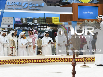 Visitors look at perched falcons while hooded during the 8th edition of the Katara International Hunting and Falcons Exhibition 2024 (S'hail...