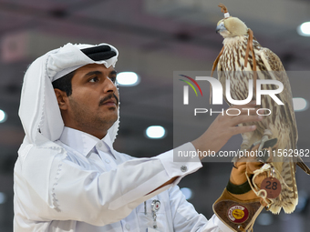 An exhibitor shows a falcon during the 8th edition of the Katara International Hunting and Falcons Exhibition 2024 (S'hail) at Katara Cultur...