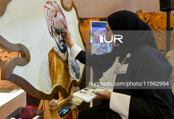 An artist paints a falcon during the 8th edition of the Katara International Hunting and Falcons Exhibition 2024 (S'hail) at Katara Cultural...