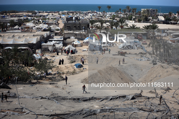 A Palestinian youth inspects the damage at the site of Israeli strikes on a makeshift displacement camp in Mawasi Khan Yunis in the Gaza Str...