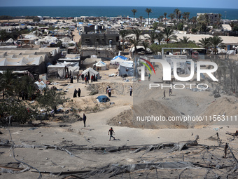 A Palestinian youth inspects the damage at the site of Israeli strikes on a makeshift displacement camp in Mawasi Khan Yunis in the Gaza Str...