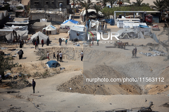 A Palestinian youth inspects the damage at the site of Israeli strikes on a makeshift displacement camp in Mawasi Khan Yunis in the Gaza Str...