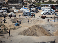 A Palestinian youth inspects the damage at the site of Israeli strikes on a makeshift displacement camp in Mawasi Khan Yunis in the Gaza Str...