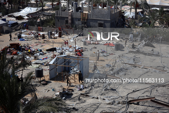 A Palestinian youth inspects the damage at the site of Israeli strikes on a makeshift displacement camp in Mawasi Khan Yunis in the Gaza Str...