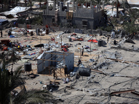 A Palestinian youth inspects the damage at the site of Israeli strikes on a makeshift displacement camp in Mawasi Khan Yunis in the Gaza Str...