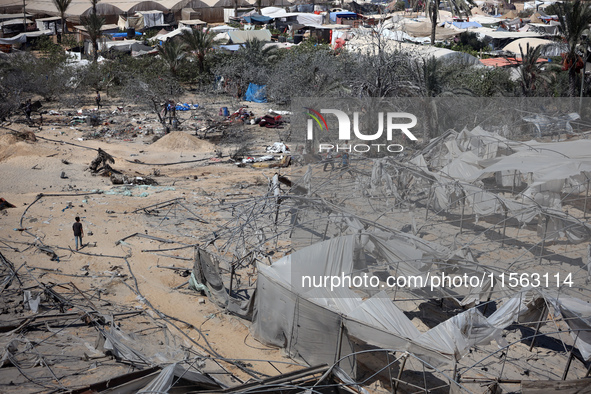 A Palestinian youth inspects the damage at the site of Israeli strikes on a makeshift displacement camp in Mawasi Khan Yunis in the Gaza Str...