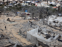 A Palestinian youth inspects the damage at the site of Israeli strikes on a makeshift displacement camp in Mawasi Khan Yunis in the Gaza Str...