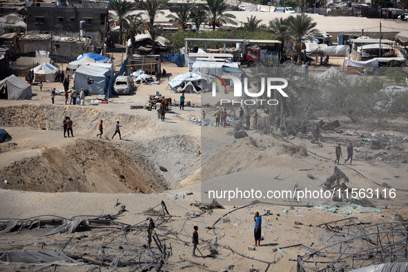 A Palestinian youth inspects the damage at the site of Israeli strikes on a makeshift displacement camp in Mawasi Khan Yunis in the Gaza Str...