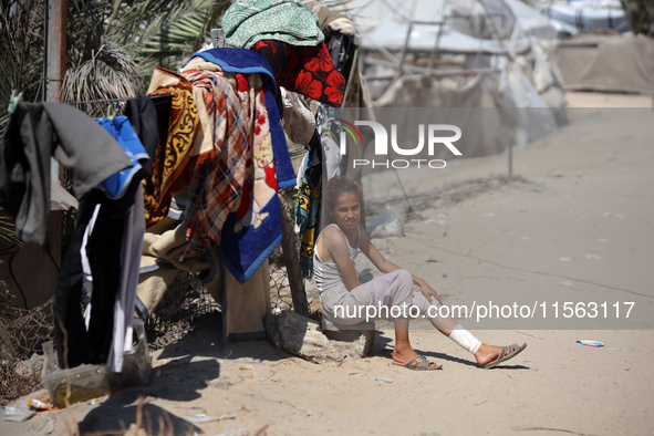 A Palestinian youth inspects the damage at the site of Israeli strikes on a makeshift displacement camp in Mawasi Khan Yunis in the Gaza Str...