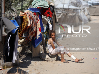 A Palestinian youth inspects the damage at the site of Israeli strikes on a makeshift displacement camp in Mawasi Khan Yunis in the Gaza Str...