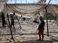 Palestinians inspect the damage at the site of Israeli strikes on a makeshift displacement camp in Mawasi Khan Yunis in the Gaza Strip on Se...