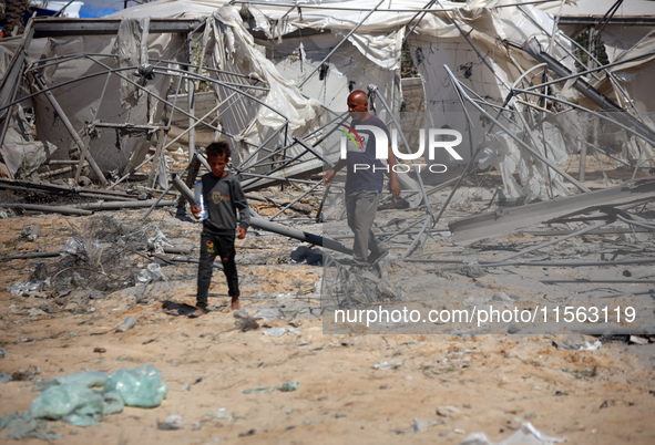 Palestinians inspect the damage at the site of Israeli strikes on a makeshift displacement camp in Mawasi Khan Yunis in the Gaza Strip on Se...