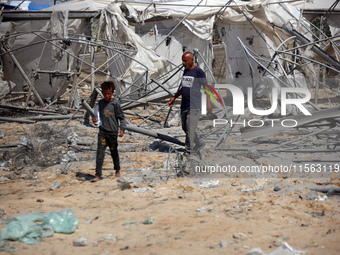 Palestinians inspect the damage at the site of Israeli strikes on a makeshift displacement camp in Mawasi Khan Yunis in the Gaza Strip on Se...