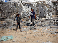 Palestinians inspect the damage at the site of Israeli strikes on a makeshift displacement camp in Mawasi Khan Yunis in the Gaza Strip on Se...