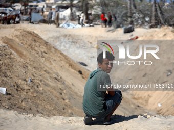 Palestinians inspect the damage at the site of Israeli strikes on a makeshift displacement camp in Mawasi Khan Yunis in the Gaza Strip on Se...