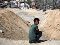 Palestinians inspect the damage at the site of Israeli strikes on a makeshift displacement camp in Mawasi Khan Yunis in the Gaza Strip on Se...