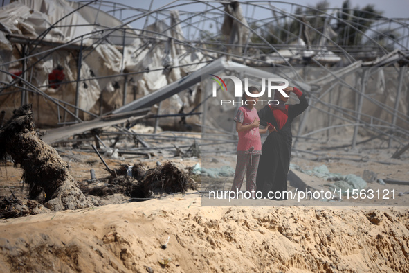 Palestinians inspect the damage at the site of Israeli strikes on a makeshift displacement camp in Mawasi Khan Yunis in the Gaza Strip on Se...