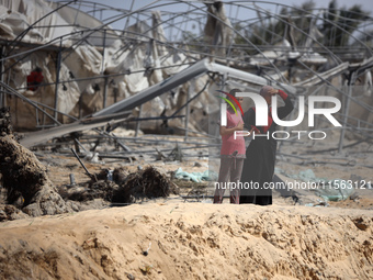 Palestinians inspect the damage at the site of Israeli strikes on a makeshift displacement camp in Mawasi Khan Yunis in the Gaza Strip on Se...