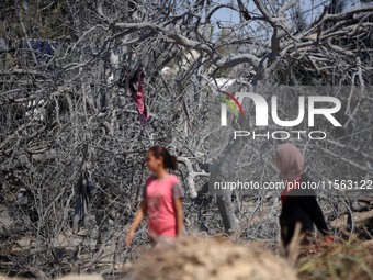 Palestinians inspect the damage at the site of Israeli strikes on a makeshift displacement camp in Mawasi Khan Yunis in the Gaza Strip on Se...