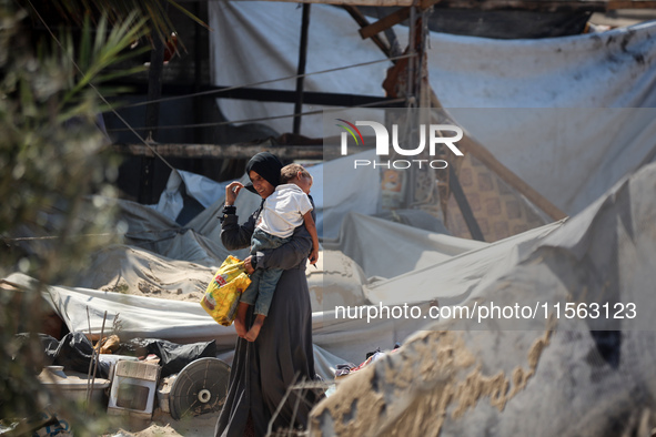 Palestinians inspect the damage at the site of Israeli strikes on a makeshift displacement camp in Mawasi Khan Yunis in the Gaza Strip on Se...