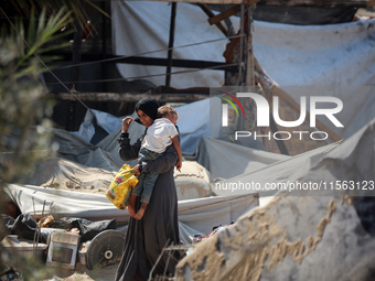 Palestinians inspect the damage at the site of Israeli strikes on a makeshift displacement camp in Mawasi Khan Yunis in the Gaza Strip on Se...