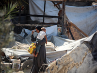 Palestinians inspect the damage at the site of Israeli strikes on a makeshift displacement camp in Mawasi Khan Yunis in the Gaza Strip on Se...