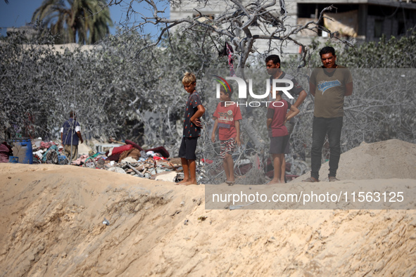 A Palestinian youth inspects the damage at the site of Israeli strikes on a makeshift displacement camp in Mawasi Khan Yunis in the Gaza Str...