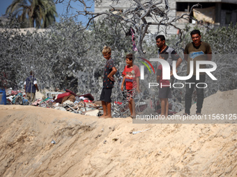 A Palestinian youth inspects the damage at the site of Israeli strikes on a makeshift displacement camp in Mawasi Khan Yunis in the Gaza Str...