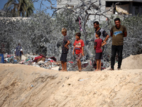 A Palestinian youth inspects the damage at the site of Israeli strikes on a makeshift displacement camp in Mawasi Khan Yunis in the Gaza Str...