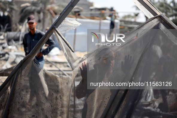 A Palestinian youth inspects the damage at the site of Israeli strikes on a makeshift displacement camp in Mawasi Khan Yunis in the Gaza Str...