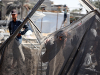 A Palestinian youth inspects the damage at the site of Israeli strikes on a makeshift displacement camp in Mawasi Khan Yunis in the Gaza Str...