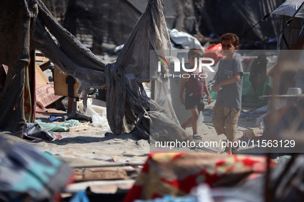 Palestinians inspect the damage at the site of Israeli strikes on a makeshift displacement camp in Mawasi Khan Yunis in the Gaza Strip on Se...