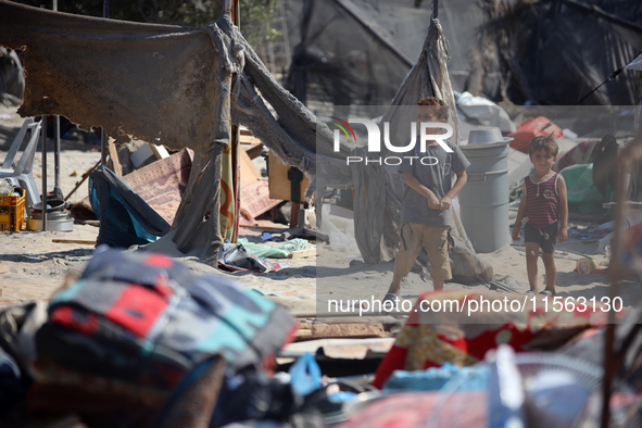 Palestinians inspect the damage at the site of Israeli strikes on a makeshift displacement camp in Mawasi Khan Yunis in the Gaza Strip on Se...