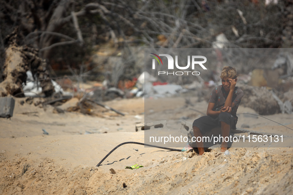 A Palestinian youth inspects the damage at the site of Israeli strikes on a makeshift displacement camp in Mawasi Khan Yunis in the Gaza Str...