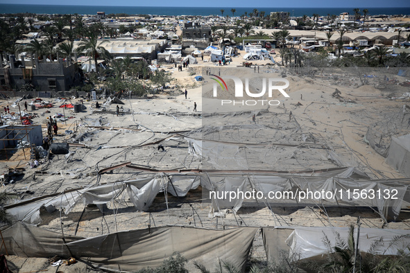 Palestinians inspect the damage at the site of Israeli strikes on a makeshift displacement camp in Mawasi Khan Yunis in the Gaza Strip on Se...