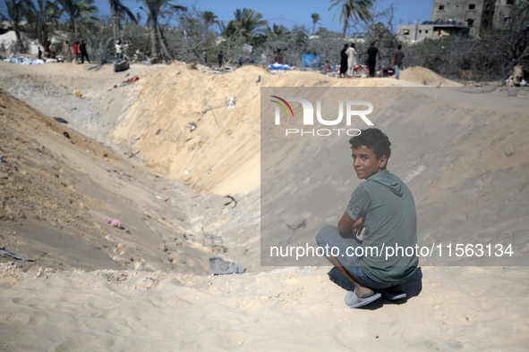 Palestinians inspect the damage at the site of Israeli strikes on a makeshift displacement camp in Mawasi Khan Yunis in the Gaza Strip on Se...